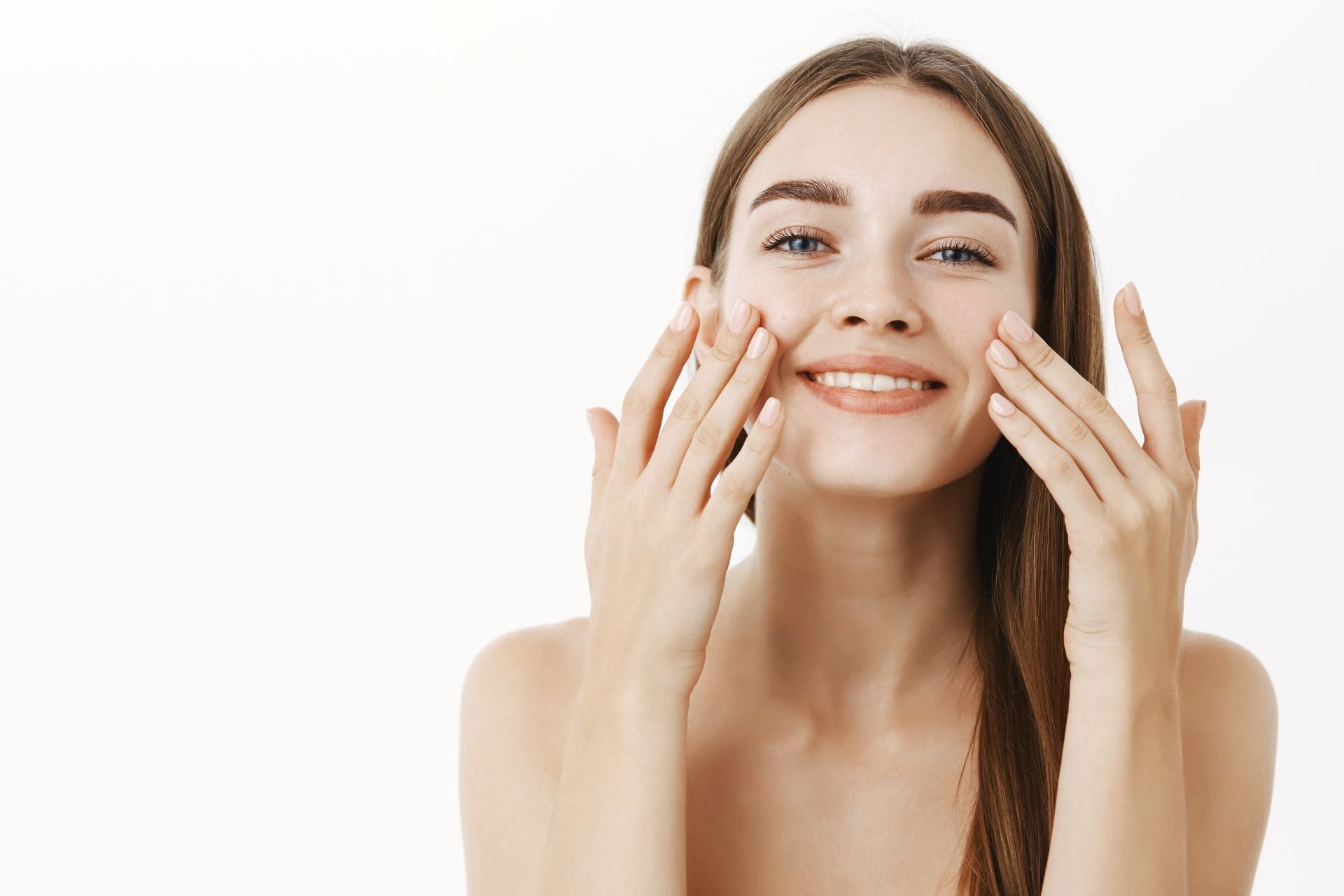 A smiling woman touching the skin of her face - wonder of protein.