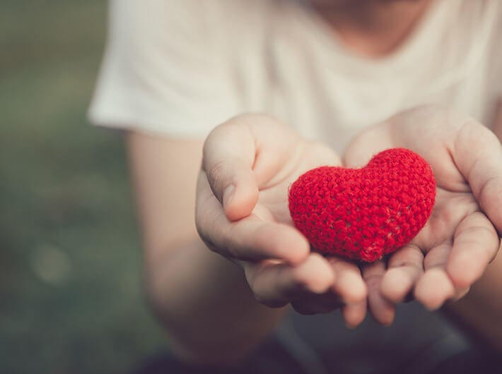 Heart Health with a person holding a fabric heart in their hands.