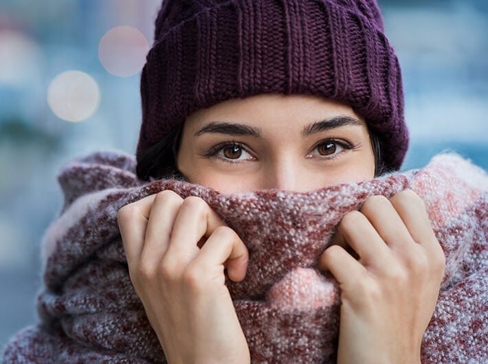 Immunity - A woman with a winter cap covering her mouth with a warm sweater.