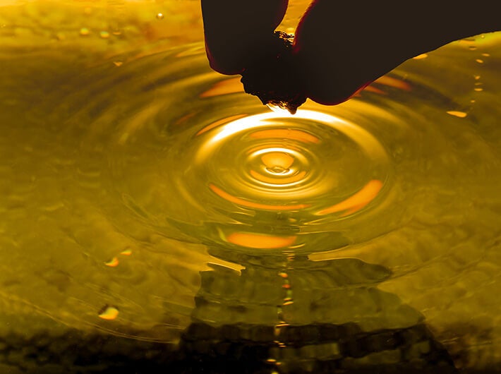 Minerals - A person dipping a food item into a liquid.